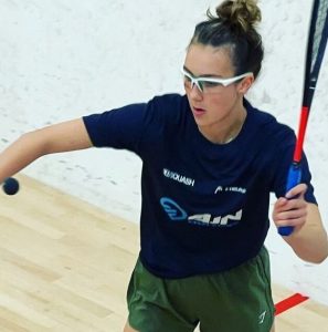 AJN Steelstock sponsored Emma Bartley about to hit the ball to serve in squash