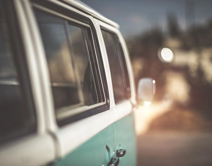 A camper van sitting next to a road with everything else out of focus
