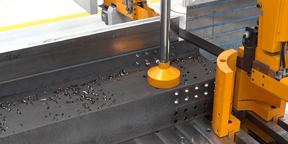 CNC Drilling - AJN Steelstock A CNC Drilling machine working on drilling a steel beam with many holes