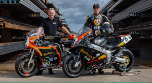 TT riders Michael Rutter and Craig Neve standing behind thier bikes and looking at the camera in a steel yard