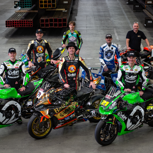 A collection of bike riders looking up and posing for a photo