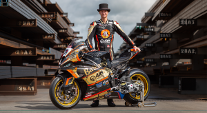 Bathams AJN Racing rider Storm Stacey standing behind his superbike in a steel stockyard looking at the camera with his hands on the bike